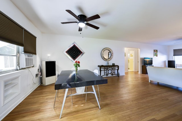 dining area featuring cooling unit, a ceiling fan, and light wood-type flooring