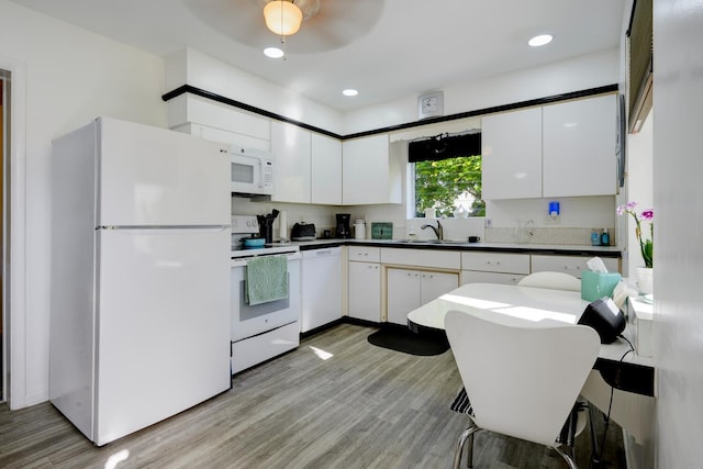 kitchen featuring a sink, white appliances, light wood-style flooring, and white cabinetry