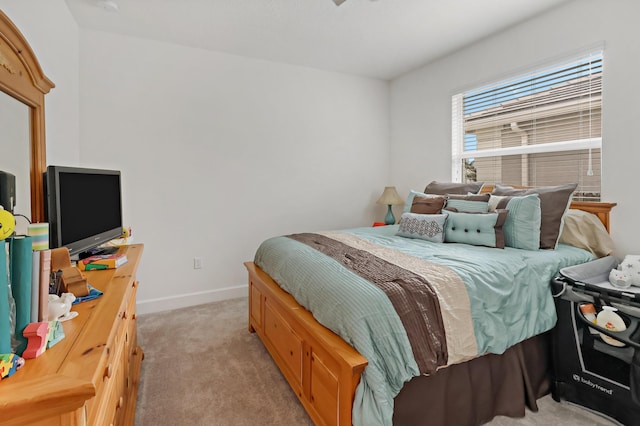 bedroom with light carpet and baseboards