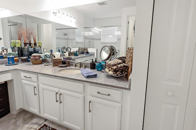 bathroom featuring visible vents, marble finish floor, a stall shower, and vanity