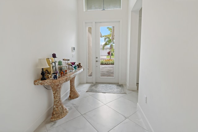 foyer with light tile patterned floors and baseboards