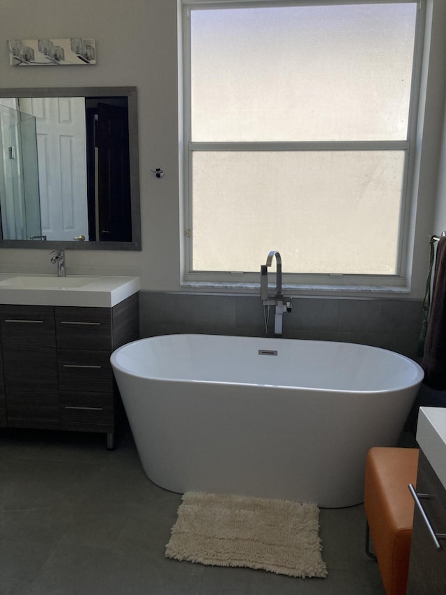 bathroom with a soaking tub and vanity