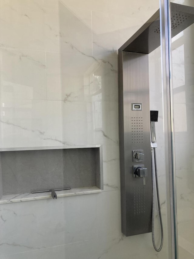 bathroom featuring a marble finish shower