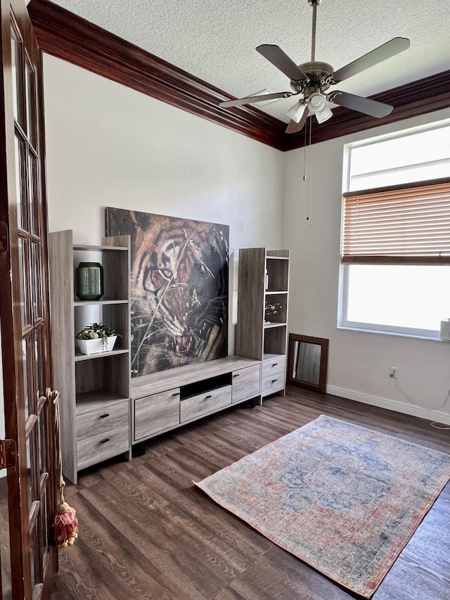 interior space featuring crown molding, wood finished floors, baseboards, and a textured ceiling