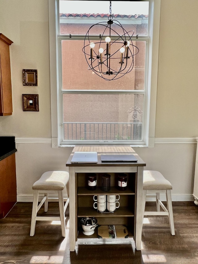 dining area featuring baseboards, a chandelier, and dark wood-style flooring