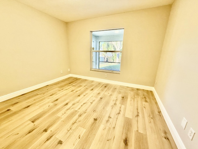 empty room with baseboards and wood finished floors