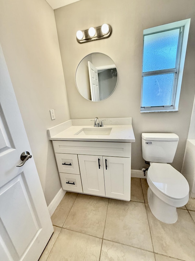 bathroom featuring tile patterned flooring, toilet, vanity, and baseboards