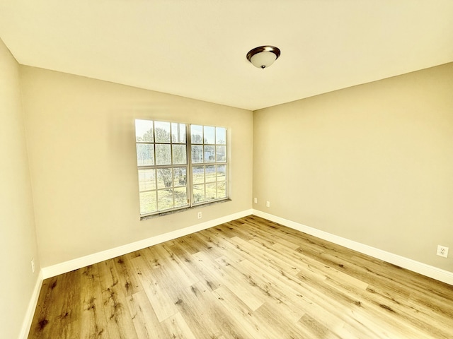 unfurnished room featuring baseboards and wood finished floors