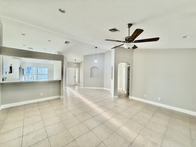 unfurnished living room featuring visible vents, lofted ceiling, baseboards, and ceiling fan with notable chandelier