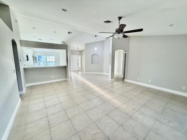 unfurnished living room featuring visible vents, baseboards, lofted ceiling, arched walkways, and a ceiling fan