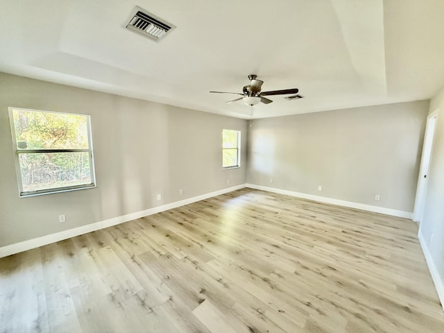 empty room with light wood-type flooring, visible vents, baseboards, and a ceiling fan