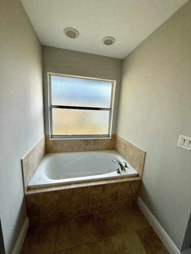 full bathroom featuring tile patterned floors, baseboards, and a garden tub