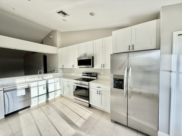 kitchen featuring visible vents, a sink, stainless steel appliances, white cabinets, and light countertops