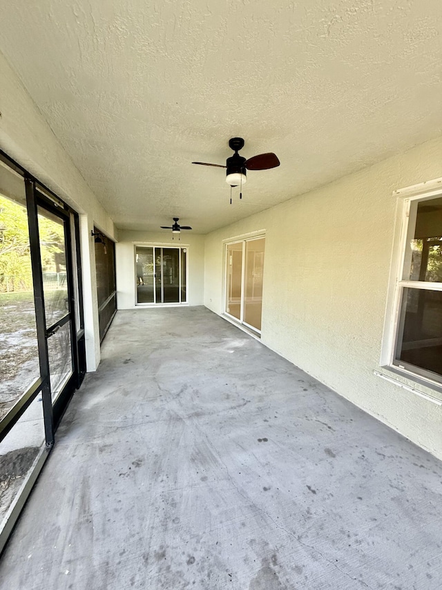 unfurnished sunroom featuring a ceiling fan