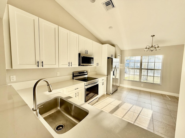 kitchen featuring visible vents, vaulted ceiling, appliances with stainless steel finishes, a notable chandelier, and a sink