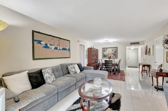 living room featuring visible vents, a textured ceiling, and light tile patterned flooring