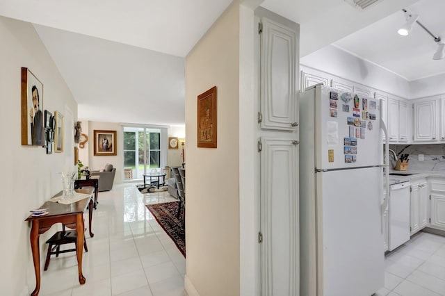 kitchen featuring white appliances, light tile patterned floors, light countertops, and tasteful backsplash