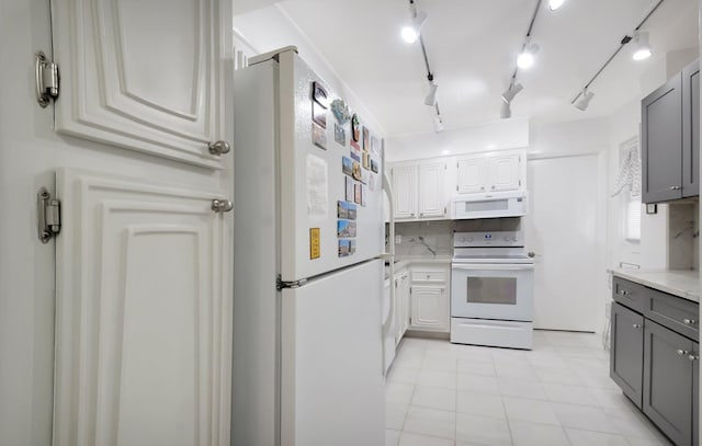 kitchen featuring white appliances, white cabinets, backsplash, and gray cabinetry