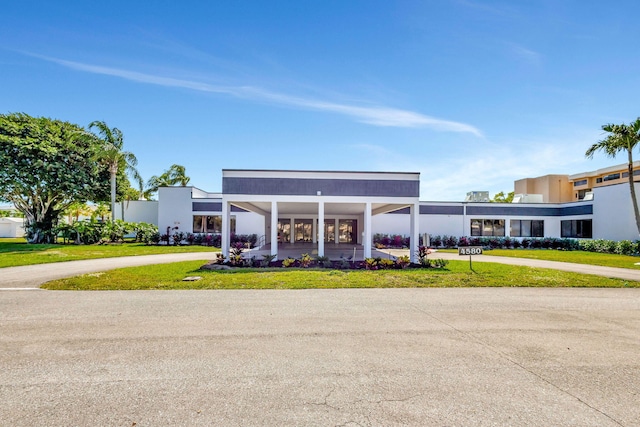 exterior space with a lawn and curved driveway