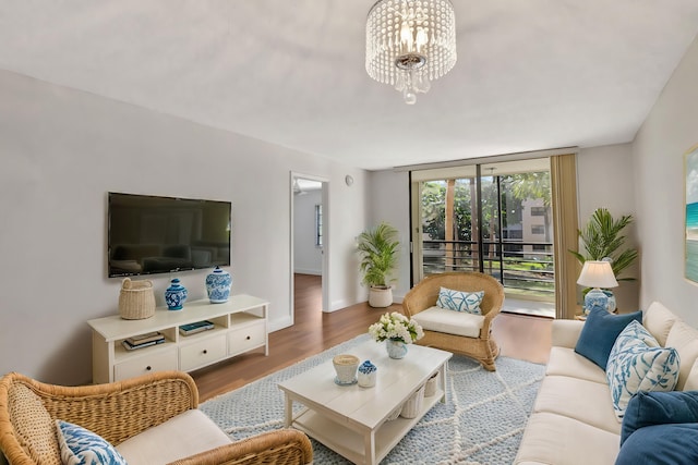 living room with a wall of windows, baseboards, an inviting chandelier, and wood finished floors