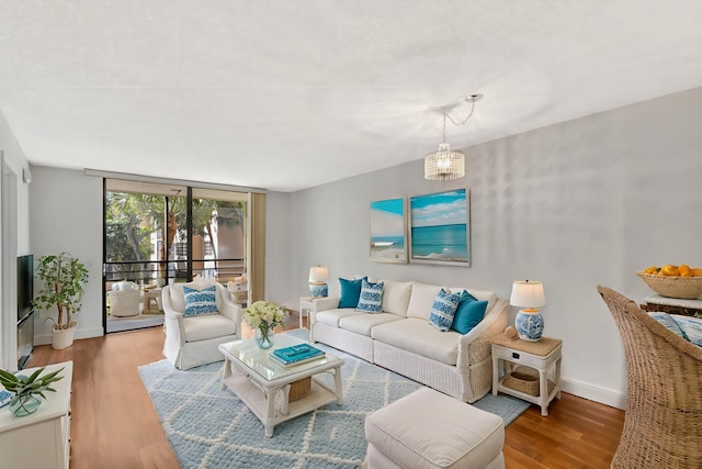 living room with floor to ceiling windows, wood finished floors, and baseboards