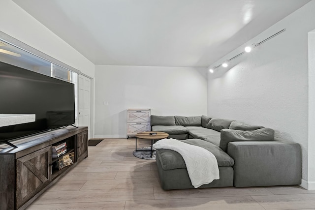 living room featuring rail lighting, baseboards, and wood tiled floor