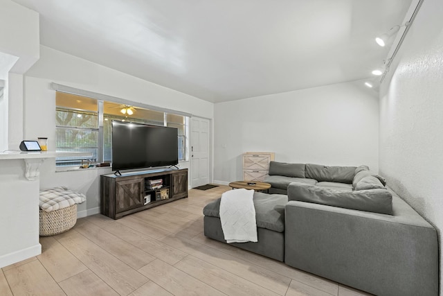 living area featuring track lighting, light wood-type flooring, and baseboards