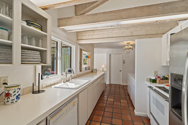 kitchen featuring white appliances, white cabinets, light countertops, and a sink