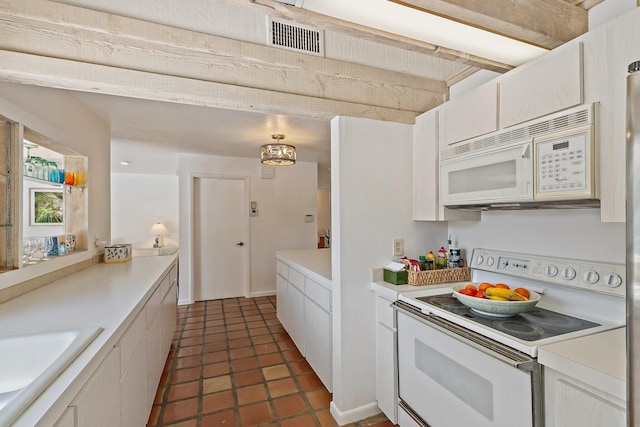 kitchen with visible vents, dark tile patterned floors, light countertops, white appliances, and a sink