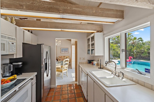 kitchen with a sink, white appliances, and light countertops