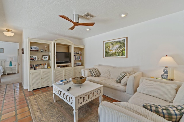 living room with visible vents, a textured ceiling, ceiling fan, and tile patterned flooring