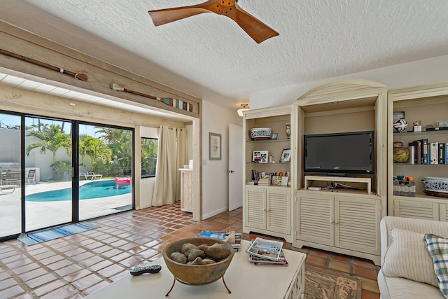 living area featuring a textured ceiling and a ceiling fan