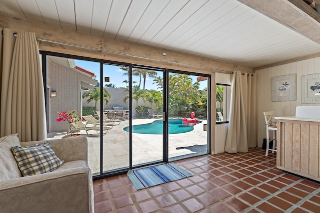 doorway to outside with wood walls and wood ceiling