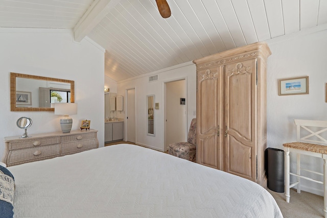 bedroom featuring visible vents, ensuite bathroom, lofted ceiling with beams, carpet floors, and crown molding