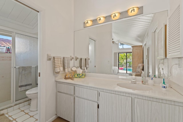 bathroom with toilet, lofted ceiling, a stall shower, ensuite bathroom, and vanity