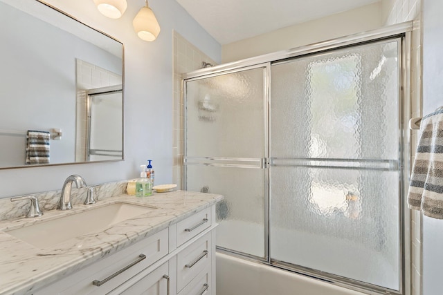 full bathroom featuring combined bath / shower with glass door and vanity