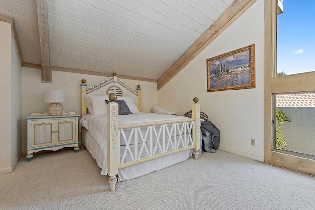 bedroom with baseboards, lofted ceiling with beams, and carpet