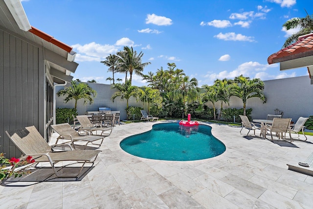 view of pool featuring a fenced in pool, outdoor dining space, and a patio area