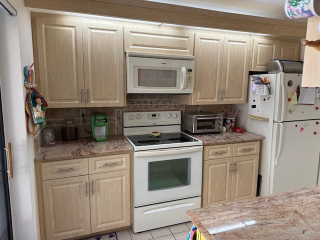 kitchen featuring light brown cabinets, a toaster, white appliances, and light countertops