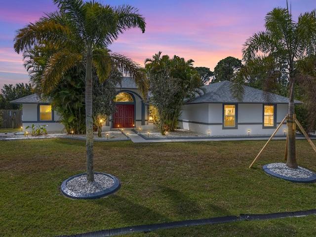 view of front of home featuring stucco siding and a front yard