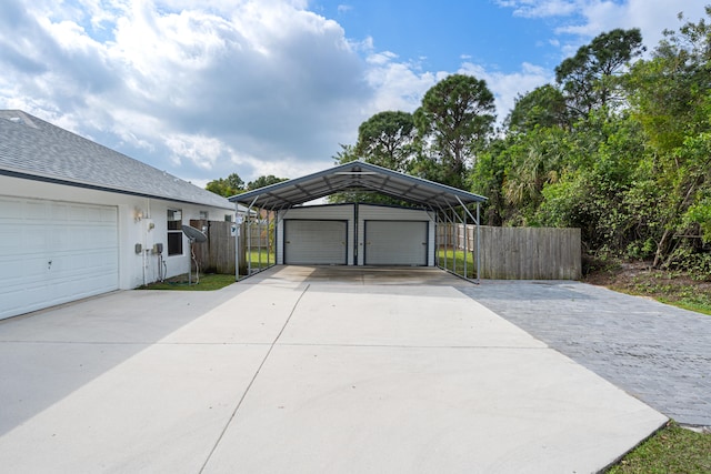 garage featuring a detached garage and fence