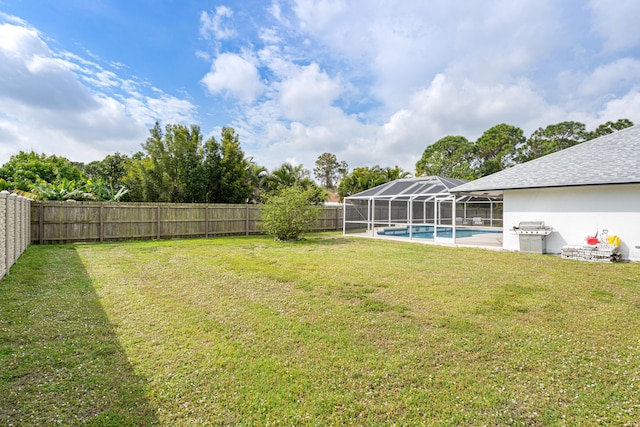 view of yard with a lanai, a fenced backyard, and a fenced in pool