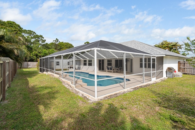 view of swimming pool featuring a yard, a patio, a fenced backyard, and glass enclosure
