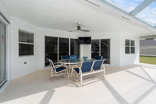 view of patio with a lanai, outdoor dining space, and a ceiling fan