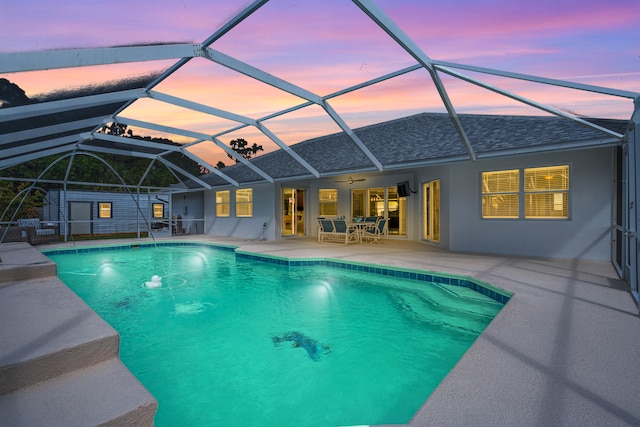pool with glass enclosure and a patio
