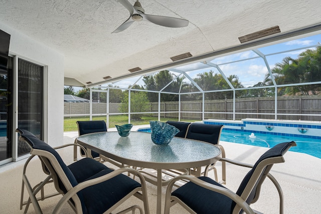 view of pool featuring a fenced in pool, ceiling fan, glass enclosure, a fenced backyard, and a patio