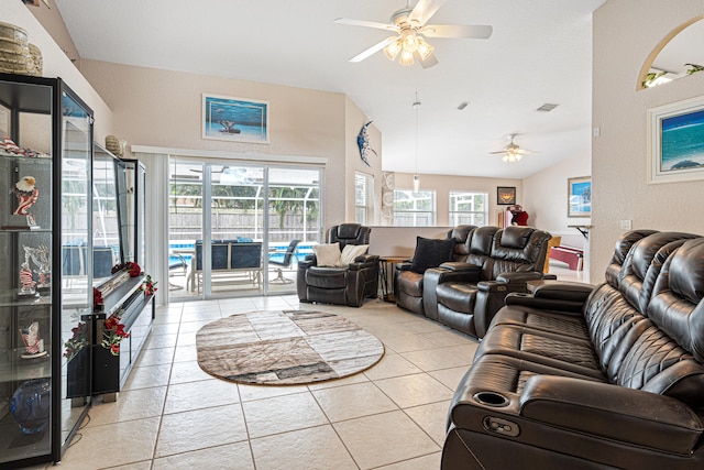 living area featuring vaulted ceiling, light tile patterned floors, visible vents, and ceiling fan