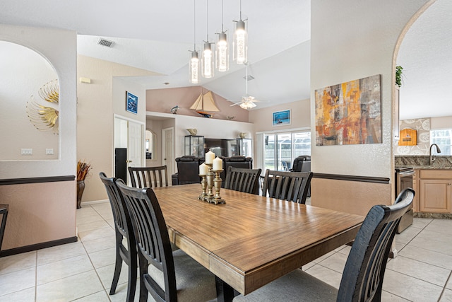dining area with light tile patterned floors, visible vents, a ceiling fan, and vaulted ceiling