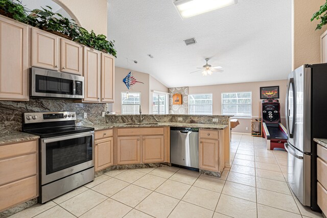 kitchen featuring visible vents, light brown cabinets, appliances with stainless steel finishes, a peninsula, and a sink