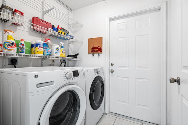 laundry room with laundry area, light tile patterned floors, and washing machine and dryer